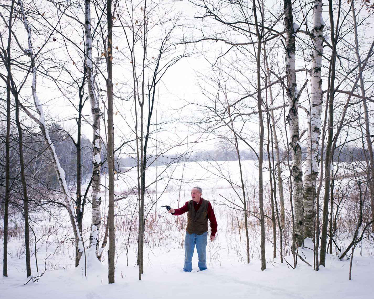 My dad with pistol in snowy wooded field portrait